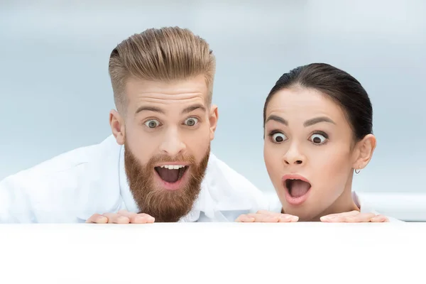 Scientists hiding behind table — Stock Photo