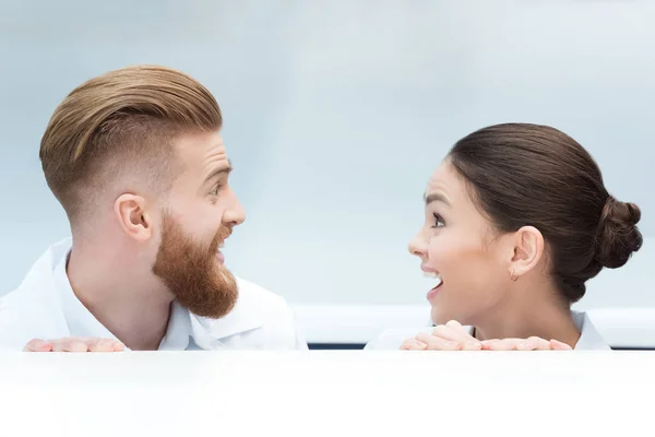 Scientists hiding behind table — Stock Photo