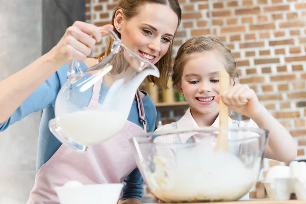 Mother and daughter preparing dough — Stock Photo