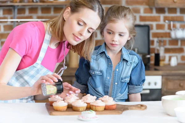 Madre e hija hornear cupcakes - foto de stock