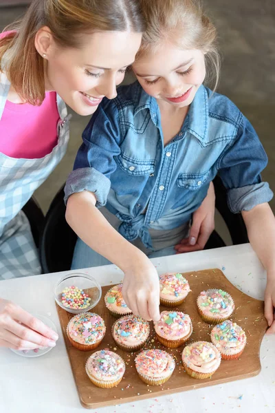 Madre e hija hornear cupcakes - foto de stock