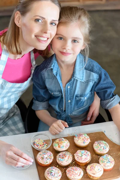 Madre e hija hornear cupcakes - foto de stock