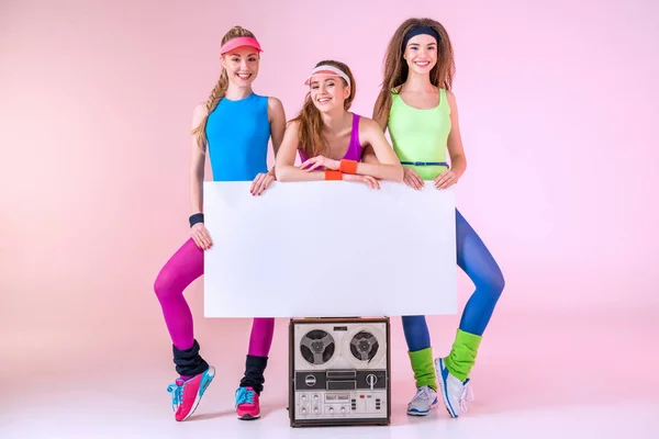 Mulheres desportivas segurando bandeira — Fotografia de Stock