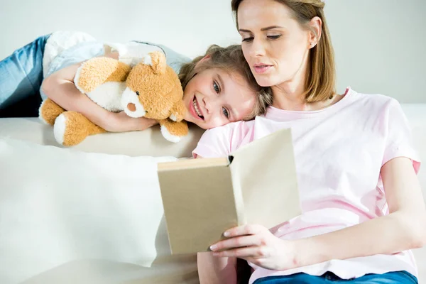 Madre e hija leyendo libro - foto de stock