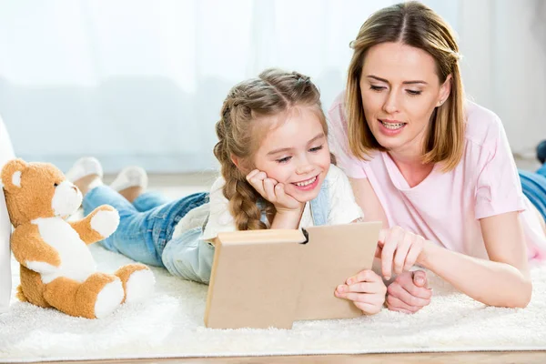 Madre e hija leyendo libro - foto de stock