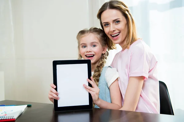 Mère et fille montrant tablette numérique — Photo de stock