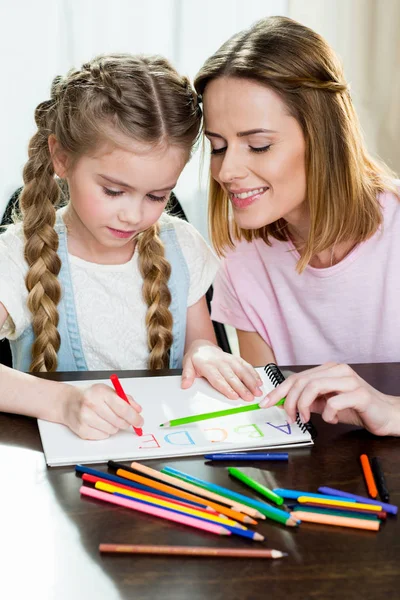 Mother and daughter drawing alphabetat — Stock Photo