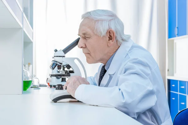 Senior chemists with microscope — Stock Photo