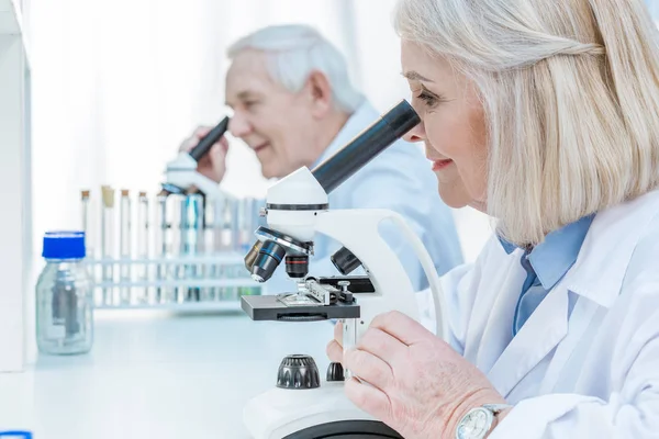 Senior chemists with microscope — Stock Photo