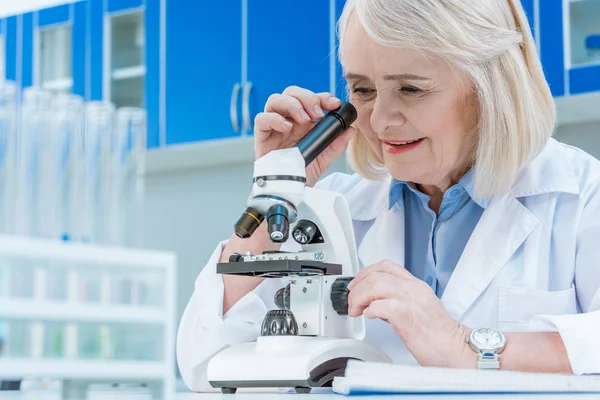 Senior chemists with microscope — Stock Photo