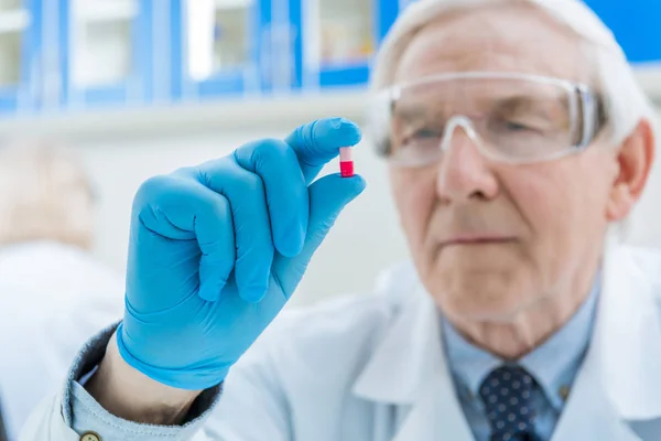 Senior scientist holding medicine — Stock Photo