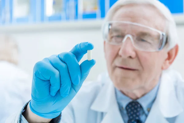 Cientista sênior segurando medicina — Fotografia de Stock
