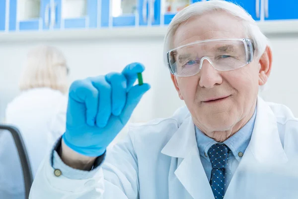 Senior scientist holding medicine — Stock Photo