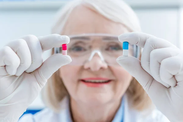 Senior scientist holding medicines — Stock Photo