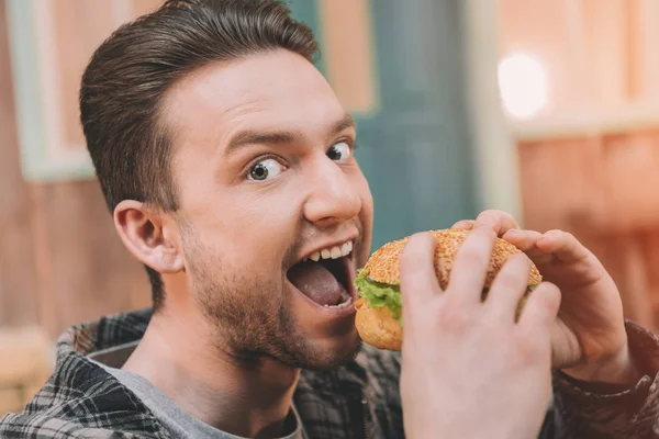 Uomo mangiare hamburger — Foto stock