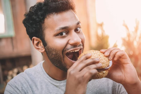 Uomo mangiare hamburger — Foto stock