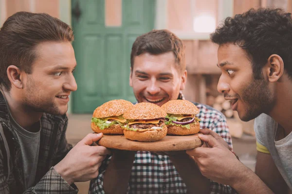 Uomini che mangiano hamburger — Foto stock