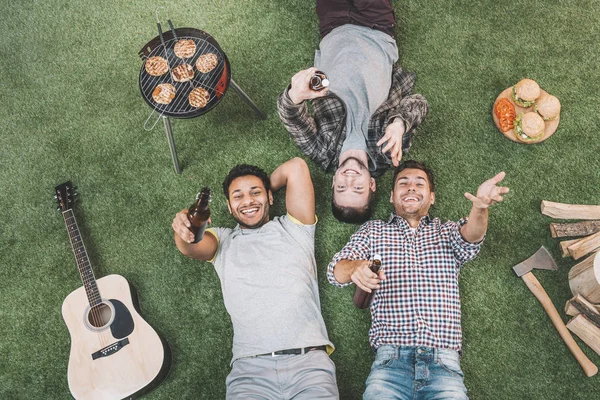 Amigos bebiendo cerveza y haciendo barbacoa — Stock Photo