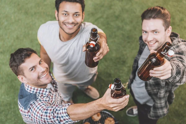 Amigos bebiendo cerveza y haciendo barbacoa - foto de stock