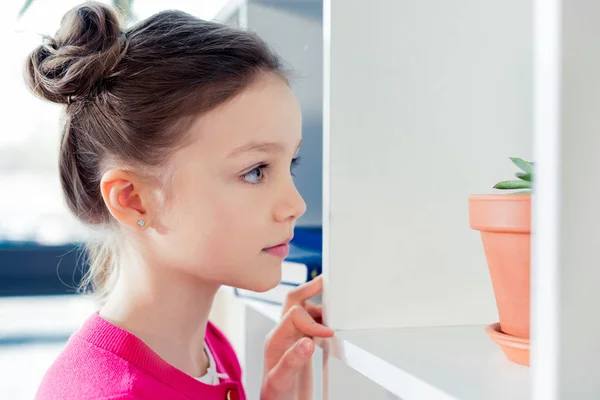 Chica mirando a houseplant - foto de stock