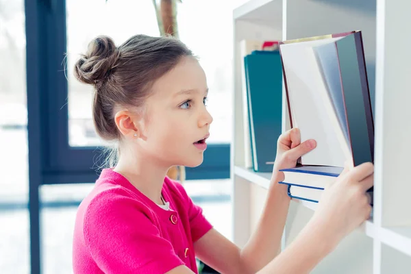 Girl choosing book — Stock Photo