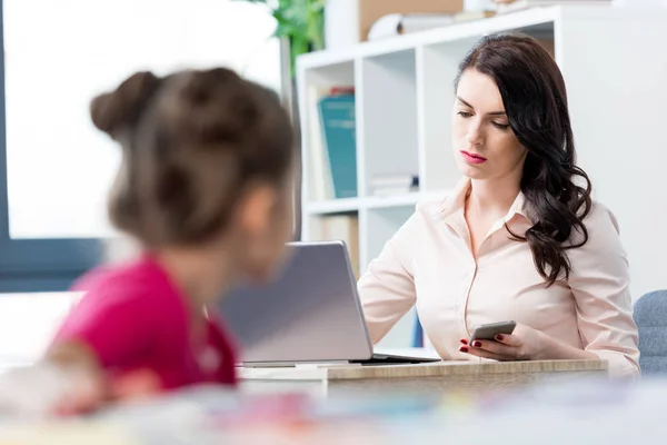 Mother and daughter at workplace — Stock Photo