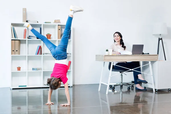 Businesswoman with daughter in office — Stock Photo