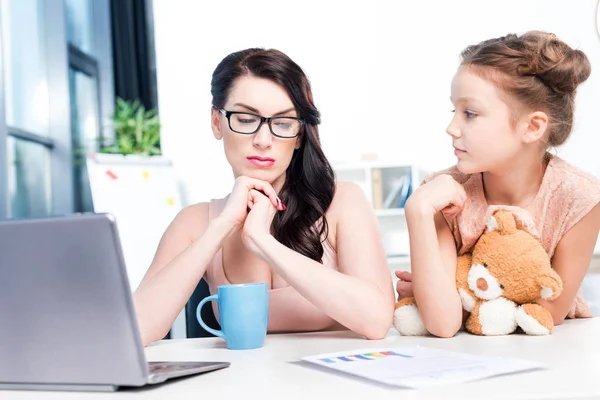 Businesswoman working with daughter — Stock Photo