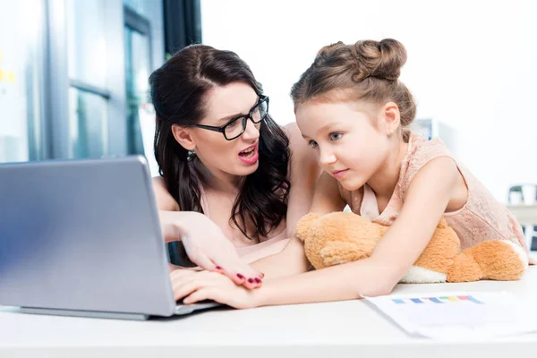 Empresaria que trabaja con su hija - foto de stock