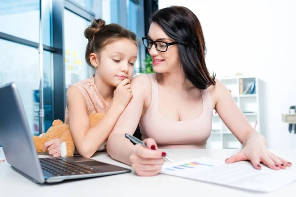 Businesswoman with daughter in office — Stock Photo