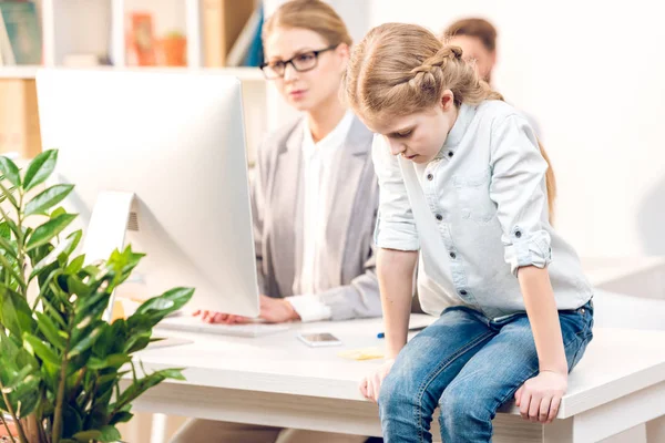 Fille assise sur la table au bureau — Photo de stock