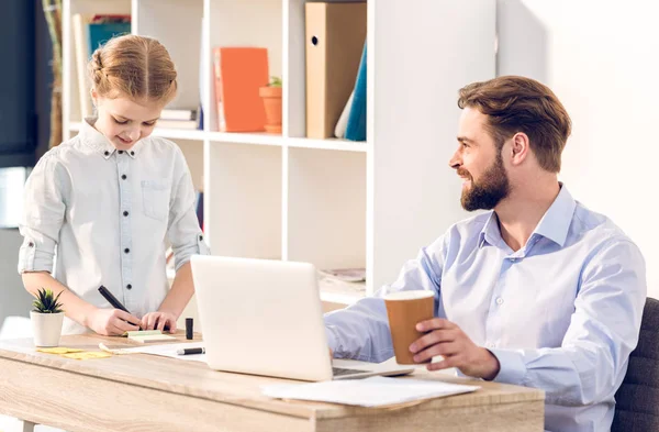 Businessman with daughter in office — Stock Photo
