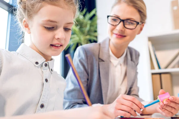 Daughter drawing with mother in office — Stock Photo