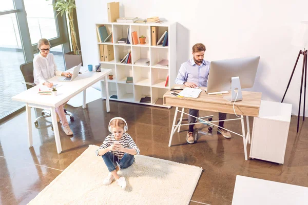 Businesswoman and businessman with daughter in office — Stock Photo