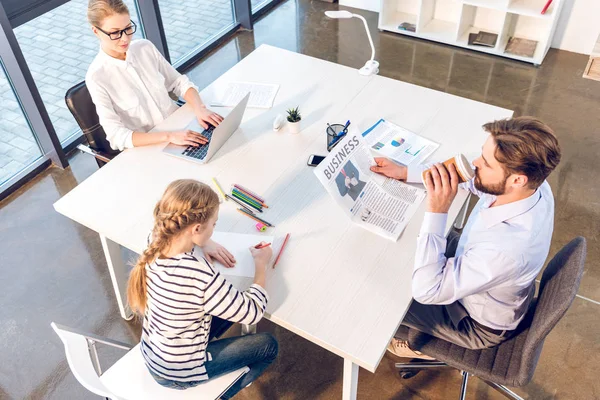 Businesswoman and businessman with daughter in office — Stock Photo