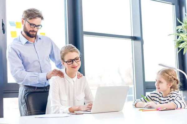 Businesswoman and businessman with daughter in office — Stock Photo