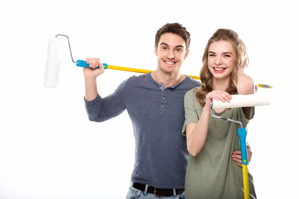 Pareja sosteniendo rodillos de pintura — Stock Photo