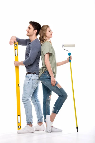 Pareja con rodillo de pintura y nivel — Stock Photo