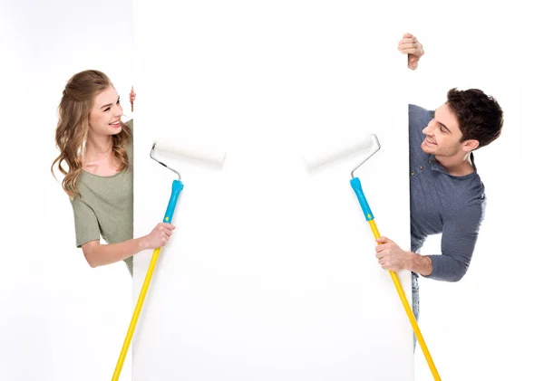 Couple holding paint rollers — Stock Photo