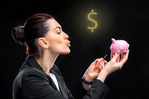 Businesswoman feeding piggy bank — Stock Photo