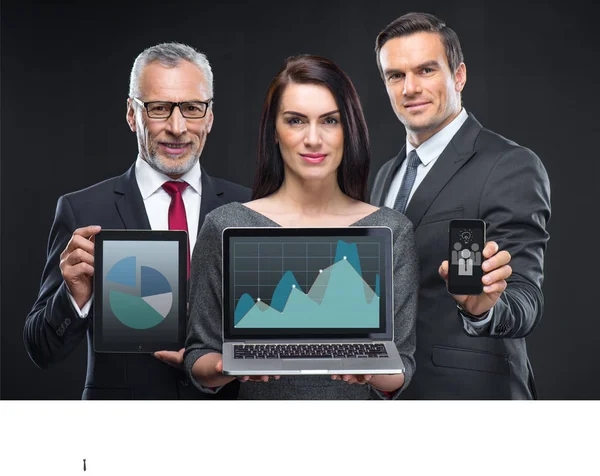 Gente de negocios que sostiene dispositivos digitales - foto de stock