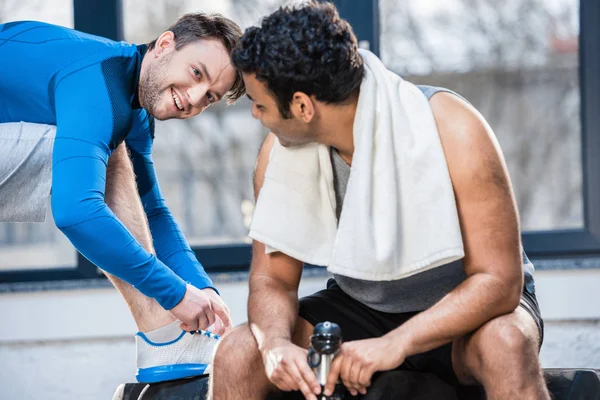 Hombre con botella de agua descansando en el gimnasio - foto de stock