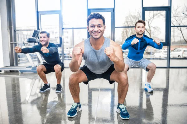 Hombres que hacen ejercicio en el centro deportivo - foto de stock