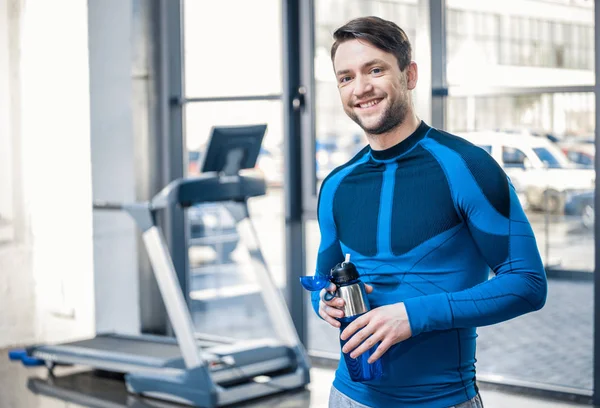 Uomo con bottiglia d'acqua in palestra — Foto stock