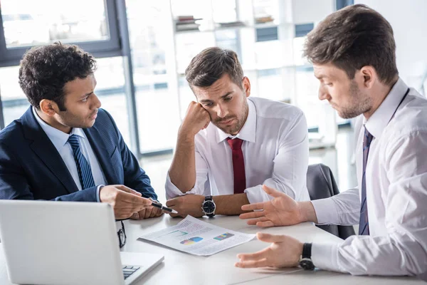 Hombres de negocios discutiendo cartas - foto de stock