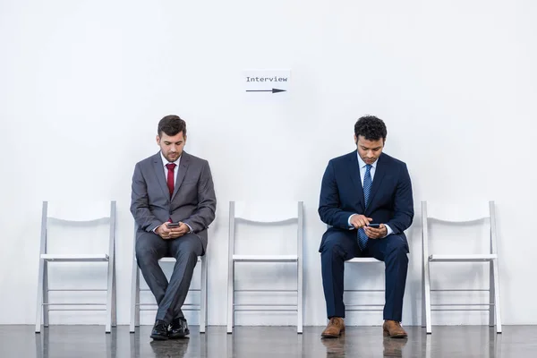 Empresarios sentados en sillas - foto de stock