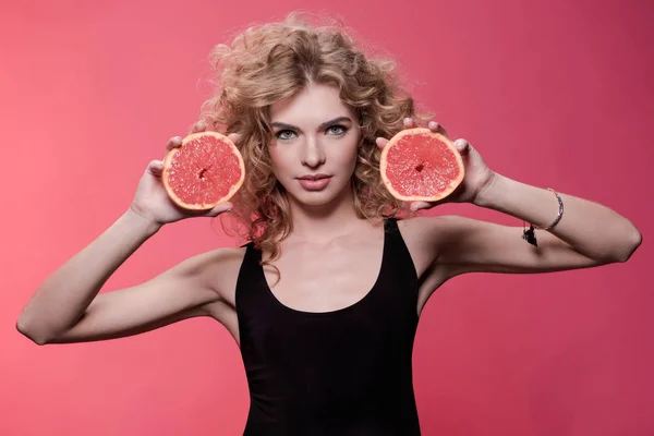 Woman holding pieces of grapefruit — Stock Photo