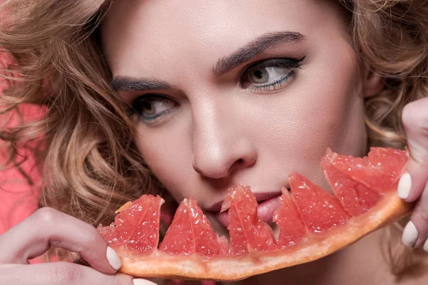 Woman holding piece of grapefruit — Stock Photo