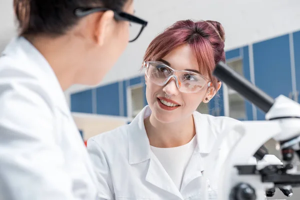 Cientistas que trabalham em conjunto com microscópios — Fotografia de Stock