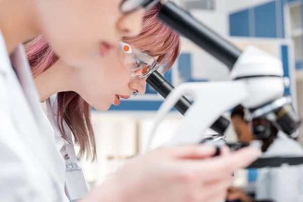 Científicos trabajando con microscopios - foto de stock